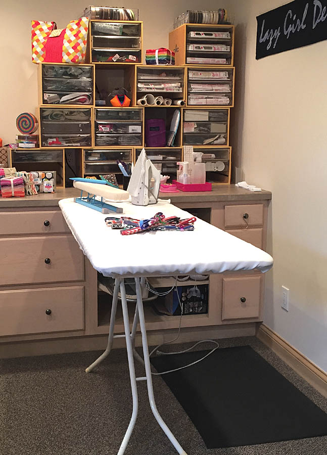 Ironing board and organized sewing supplies.