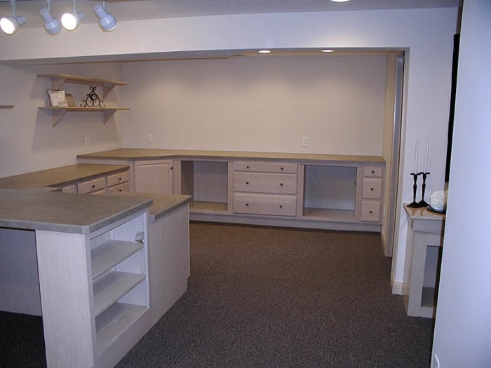 Sewing studio with built-in shelving, counters, and drawers.