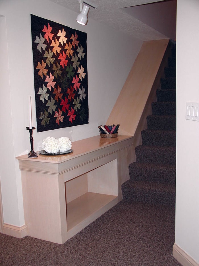 View of staircase with built-in cabinetry to create display space.