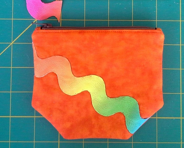 Close up of a small zipper pouch with ricrac sewn to it.