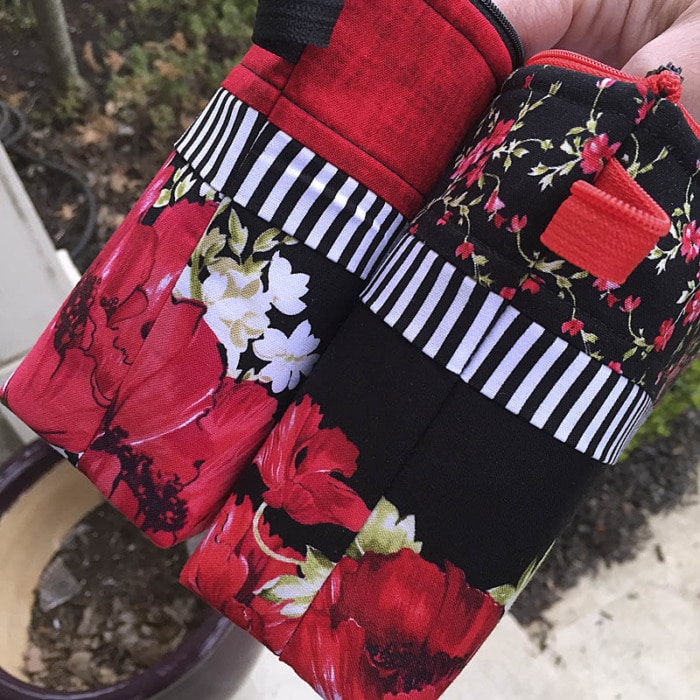 Small zippered pouch made with a border print of florals on a black background.