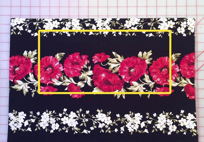 A fabric border print of florals on a black background.