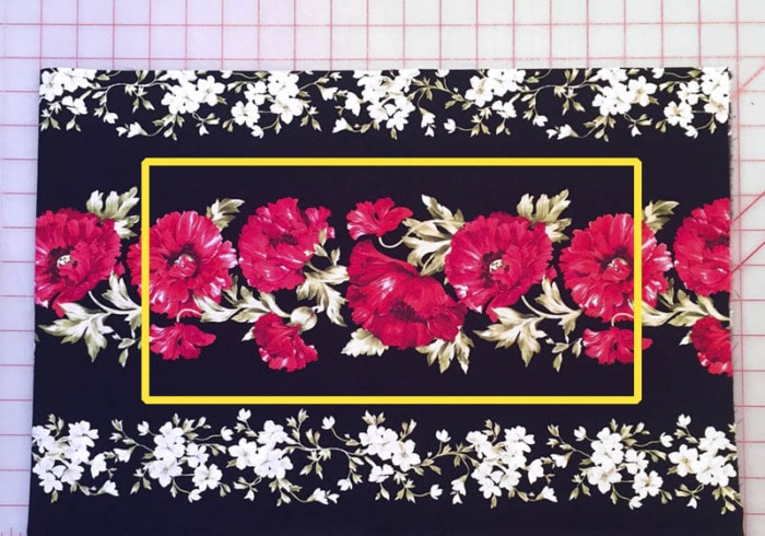 Cut a fabric border print of florals on a black background.