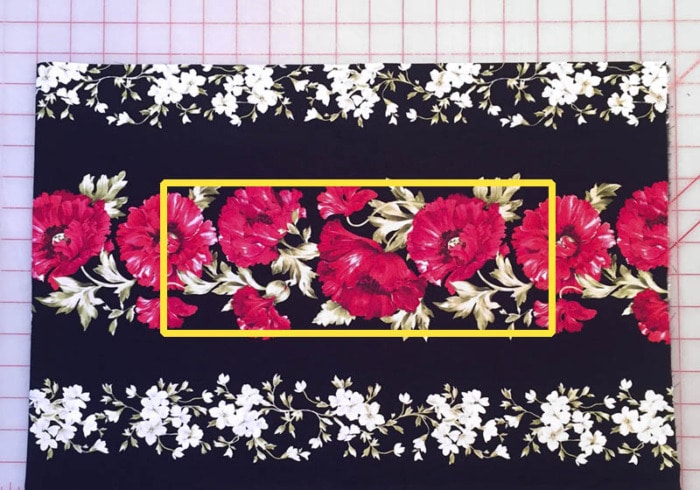 A fabric border print of florals on a black background.