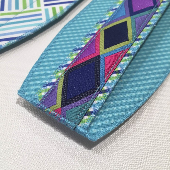Close up picture of how to finish the end of a project when sewing ribbon in place. Shows zigzag stitching.