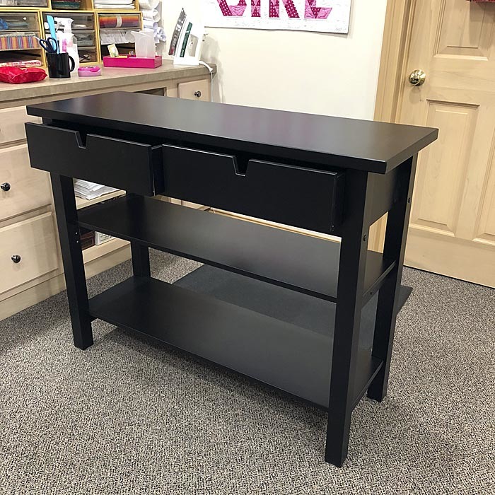 Sliding drawers and shelves of IKEA Norden wooden sideboard.