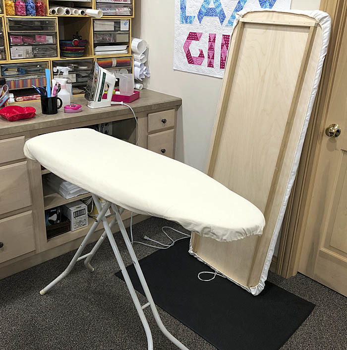 Ironing board with pointed tip and plywood ironing board topper.