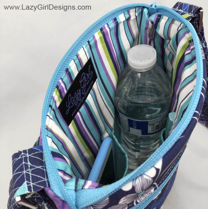 View of inside of cross body bag showing water bottle and cell phone