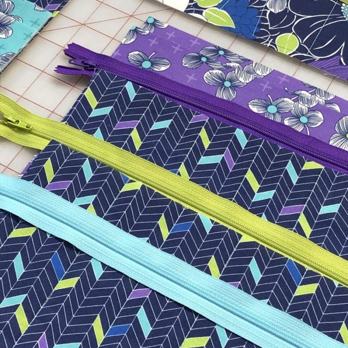 Close up of purple and blue fabric with coordinating zippers.