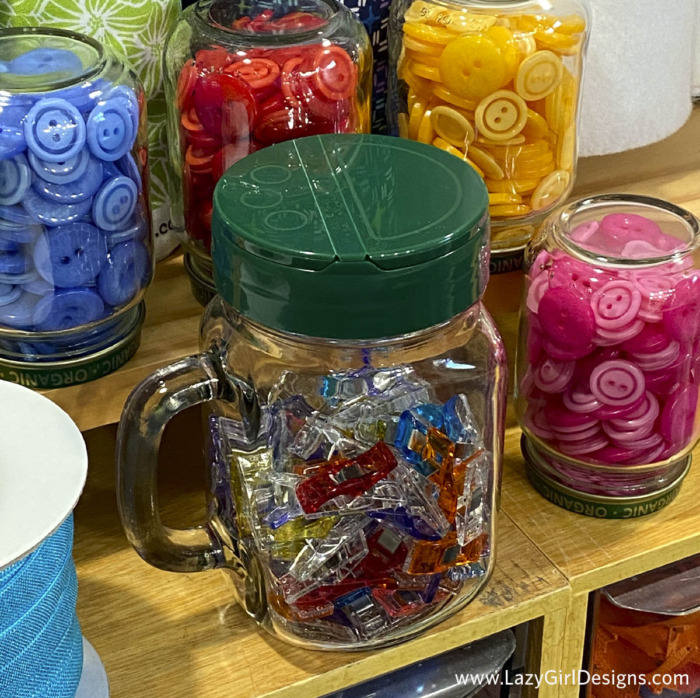 One glass jar filled with sewing clips